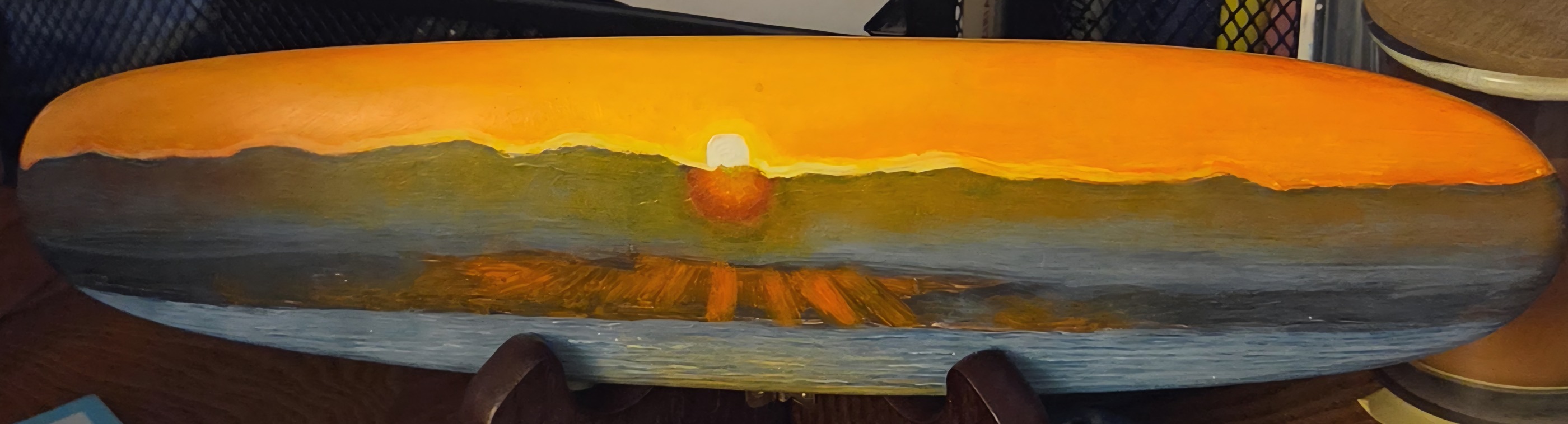Ocean sunset through clouds, a panoramic sunset painting on a surfboard